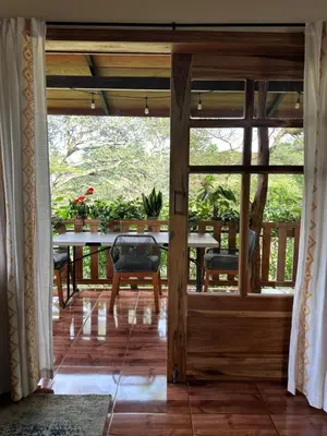 a screened in porch with a table and chairs at Cabaña Guapinol in Atenas