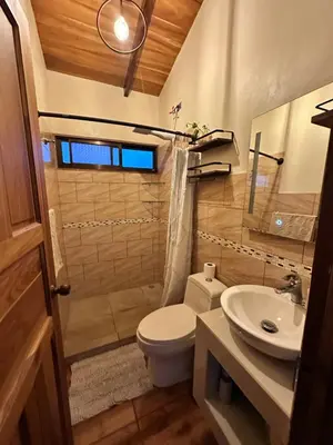 a bathroom with a toilet and a sink at Cabaña Guapinol in Atenas
