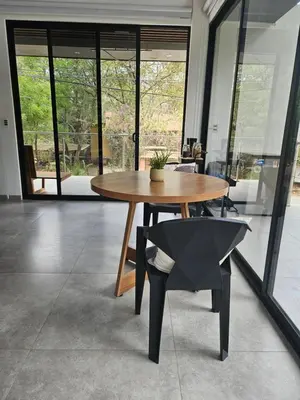 a wooden table and a chair in a room with windows at Mystica in Playa Avellana