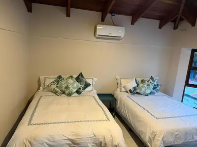 two beds in a room with a window at Tivives Kikala Lodge 2 in Puntarenas