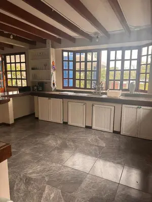 a large kitchen with white cabinets and windows at Tivives Kikala Lodge 2 in Puntarenas