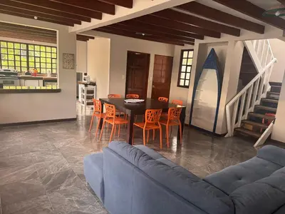 a dining room with a blue couch and a table and chairs at Tivives Kikala Lodge 2 in Puntarenas