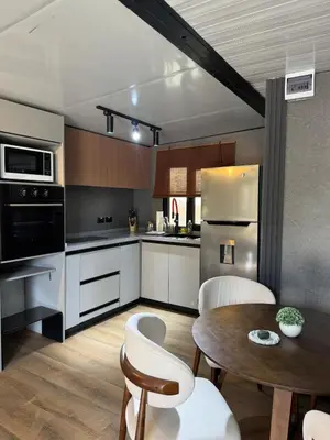 a kitchen with stainless steel appliances and a wooden table at Casa Bolsero - private, small home in Tamarindo in Tamarindo