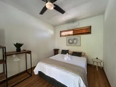 a bedroom with a bed and a ceiling fan at Casa Joy - 3 Apartment Villa in the Hills of Santa Teresa in Santa Teresa Beach