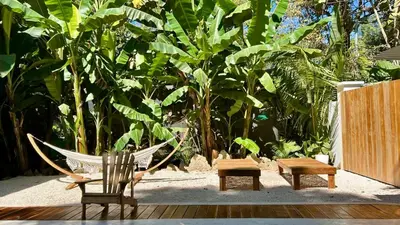 a hammock and a chair and a table and benches at Casa Joy - 3 Apartment Villa in the Hills of Santa Teresa in Santa Teresa Beach
