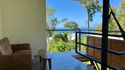a living room with a couch and a balcony at Casa Joy - 3 Apartment Villa in the Hills of Santa Teresa in Santa Teresa Beach