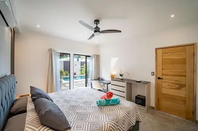 a bedroom with a bed with a ceiling fan and a desk at Casa Vineta, Apartment in Duplex, close to beach in Carrillo