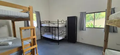 a room with two bunk beds and a window at Abacaxi Hostel in Santa Teresa Beach