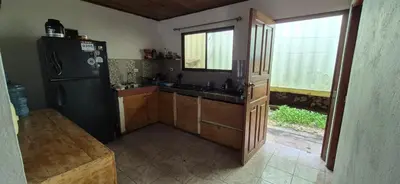 a kitchen with a black refrigerator and a window at Abacaxi Hostel in Santa Teresa Beach
