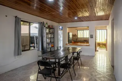 a dining room with a wooden table and chairs at Abacaxi Hostel in Santa Teresa Beach