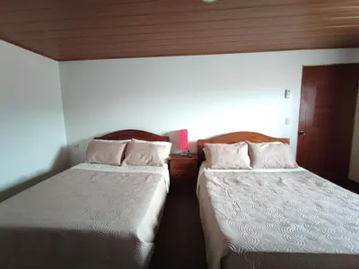 two beds sitting next to each other in a room at Apartamento completo cerca del Aeropuerto y Parque Viva 5 personas in Guácima