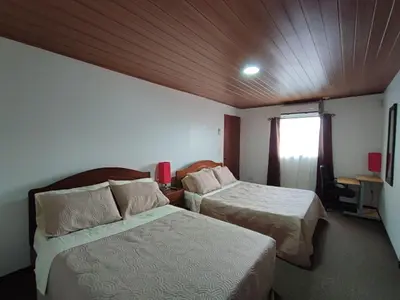 a hotel room with two beds and a window at Apartamento completo cerca del Aeropuerto y Parque Viva 5 personas in Guácima