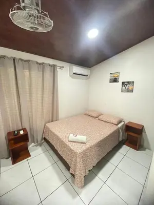 a bedroom with a bed and two night stands at Apartamento Playa Sámara in Sámara