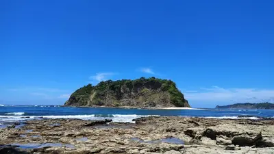 an island in the ocean on a rocky beach at Apartamento Playa Sámara in Sámara