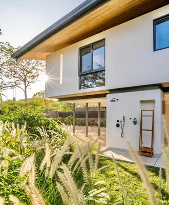 a house with a front door and grass at Nimbu Vida in Tamarindo