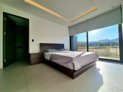a bedroom with a bed and a large window at Playa Potrero in Potrero