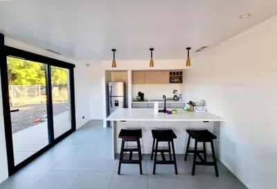 a kitchen with a white counter and two bar stools at Playa Potrero in Potrero