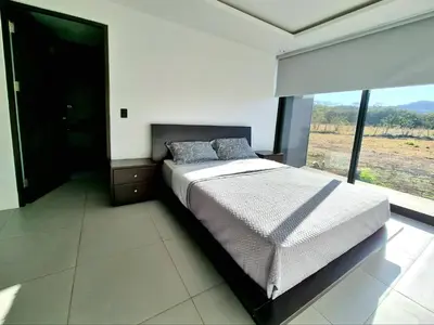 a bedroom with a bed and a large window at Playa Potrero in Potrero