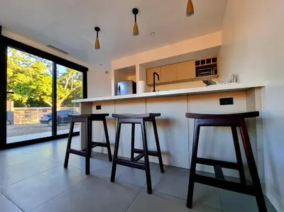 a kitchen with two bar stools and a counter at Playa Potrero in Potrero