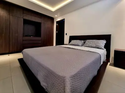 a bedroom with a large bed and a tv at Playa Potrero in Potrero