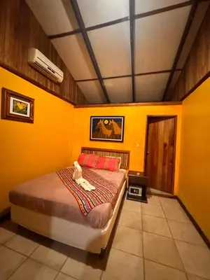 a bedroom with a bed with a white cat sitting on it at 2BR Toucans and Waterfalls- the garden cottage in Caña Blanca