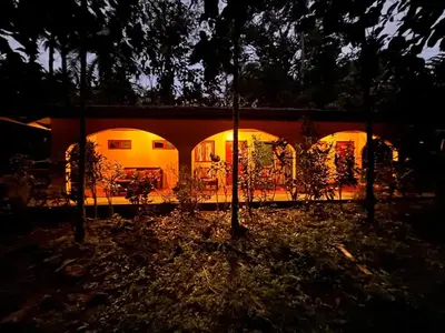a house lit up at night with lights at 2BR Toucans and Waterfalls- the garden cottage in Caña Blanca