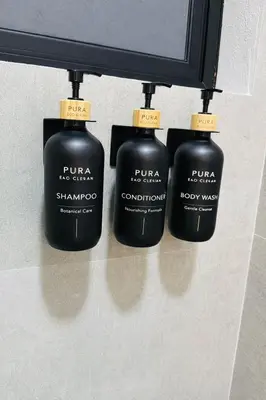 three black bottles of soap hanging on a wall at Blue Zone Private Eco Residence - Essence Suite - in Tamarindo