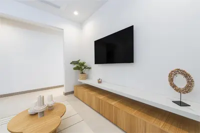 a living room with a tv on a white wall at Brisa Mar, Ocean Views, Beach Club & Pools in Sardinal