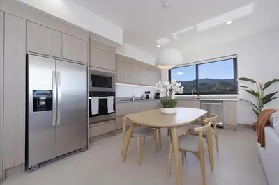 a kitchen with a table with chairs and a refrigerator at Brisa Mar, Ocean Views, Beach Club & Pools in Sardinal
