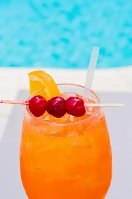 a drink with oranges and cherries on a table at Brisa Mar, Ocean Views, Beach Club & Pools in Sardinal