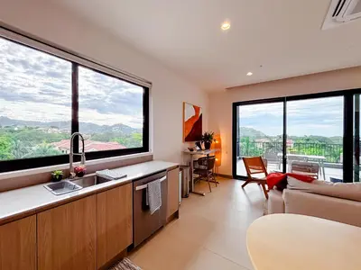 a kitchen with large windows and a living room at Sunset Terrace at Naumi, Ocean Views & Beach Club in Sardinal