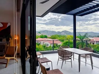 a balcony with a table and chairs and a view at Sunset Terrace at Naumi, Ocean Views & Beach Club in Sardinal