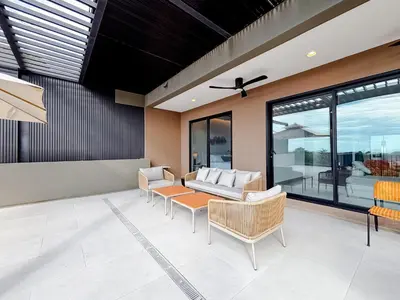 a living room with a couch and chairs at Sunset Terrace at Naumi, Ocean Views & Beach Club in Sardinal