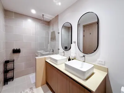 a bathroom with two sinks and two mirrors at Sunset Terrace at Naumi, Ocean Views & Beach Club in Sardinal