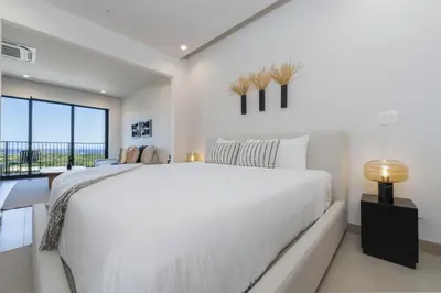 a white bedroom with a large bed and a window at Vista Paz Condo, Ocean Views & Beach Club in Sardinal