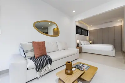 a living room with a white couch and a bed at Pacific Valley at Naumi, Beach Club, Gym, Pools in Sardinal