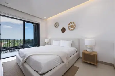 a white bedroom with a bed and a large window at Casa Matcha, BRAND NEW! Ocean Views & Beach Club in Sardinal