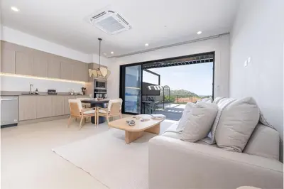 a living room with a white couch and a table at Casa Mint, Ocean Views, Pools, Gym & Beach Club in Sardinal