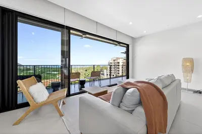 a living room with a couch and a large window at Tropics at Naumi, Ocean Views, Gym & Pools in Sardinal