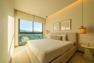 a bedroom with a white bed and a large window at Costa Azul Condo, Ocean View & Beach Club in Sardinal