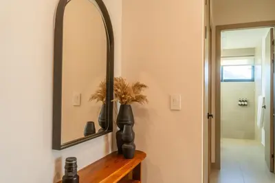 a bathroom with a mirror and a wooden table at Costa Azul Condo, Ocean View & Beach Club in Sardinal