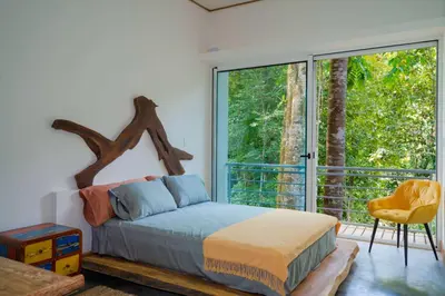 a bedroom with a bed and a large window at Casa Bromelia in Portalón