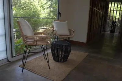 two chairs and a trash can on a balcony at Casa Bromelia in Portalón