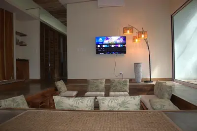 a living room with a couch and a tv on the wall at Casa Bromelia in Portalón