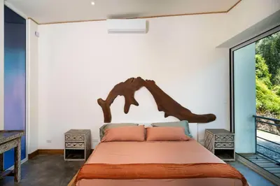 a bedroom with a large bed with a wooden headboard at Casa Bromelia in Portalón