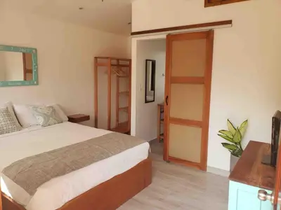a bedroom with a bed and a door to a room at La Buena vida Cabina 1 in Playa Grande