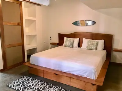a bedroom with a bed with white sheets and pillows at La Buena vida Cabina 3 in Playa Grande