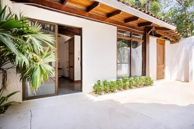 an open door of a house with plants at La Buena vida Cabina 3 in Playa Grande