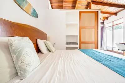 a bedroom with a large bed with a wooden headboard at La Buena vida Cabina 3 in Playa Grande