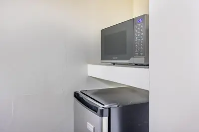 a microwave sitting on a shelf next to a refrigerator at La Buena vida Cabina 4 in Playa Grande